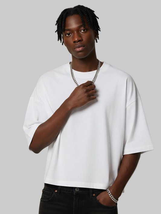 Person wearing a white t-shirt and black pants against a gray background